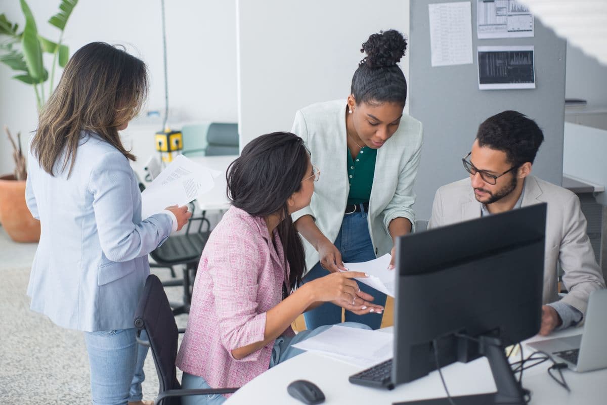 A team gathered around a desk in an open discussion